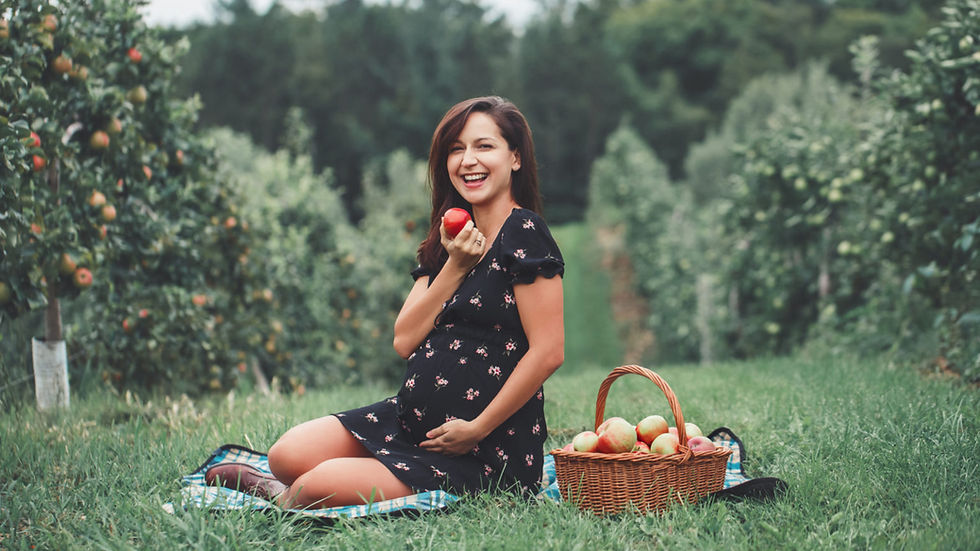 Pregnant woman in an apple orchard