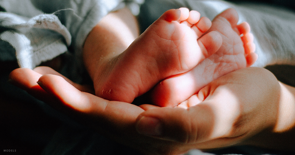 Parent holding newborn's feet.