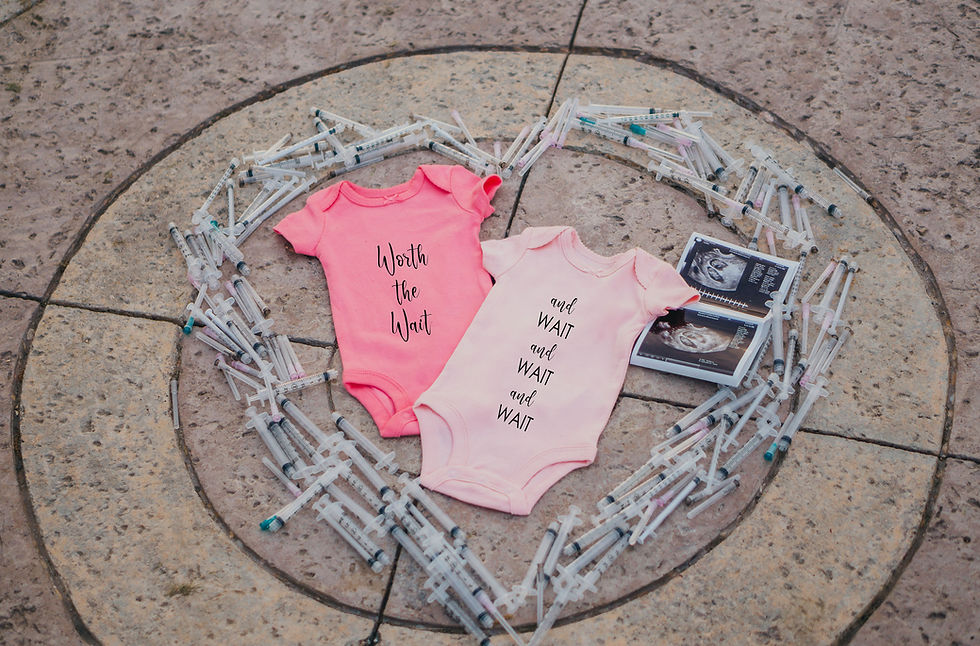 Baby onesies surrounded by a heart made of syringes
