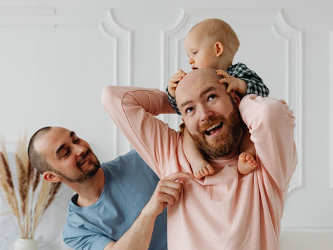 Happy family moment with two dads and their son (models)