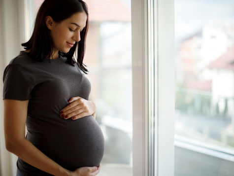 Pregnant woman holding her pregnant belly (model)
