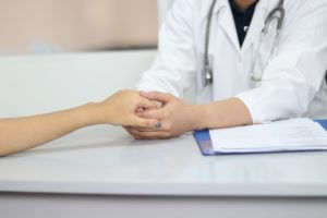 close up on a doctor holding patient's hand