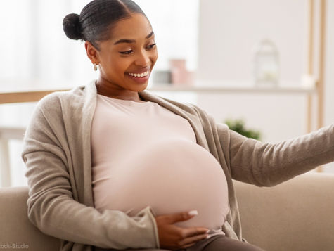Pregnant woman taking a selfie, smiling at the camera (model). Credit: Getty Images / Prostock-Studio.