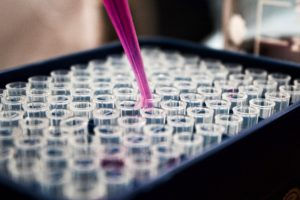 box of test tubs with vial filling one