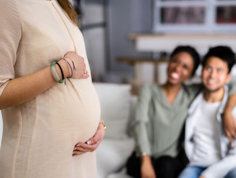 Pregnant Woman Touching Her Belly's Woman Standing In Front - stock photo. Source: Getty Images. Credit: AndreyPopov