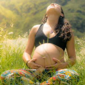 Pregnant woman sitting in field