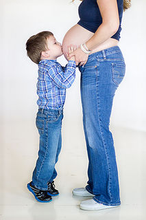 young boy kissing pregnant belly