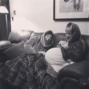 Surrogate and expecting mother laughing together