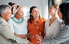 4 women touching pregnant woman's belly