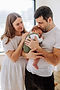 parents holding baby close