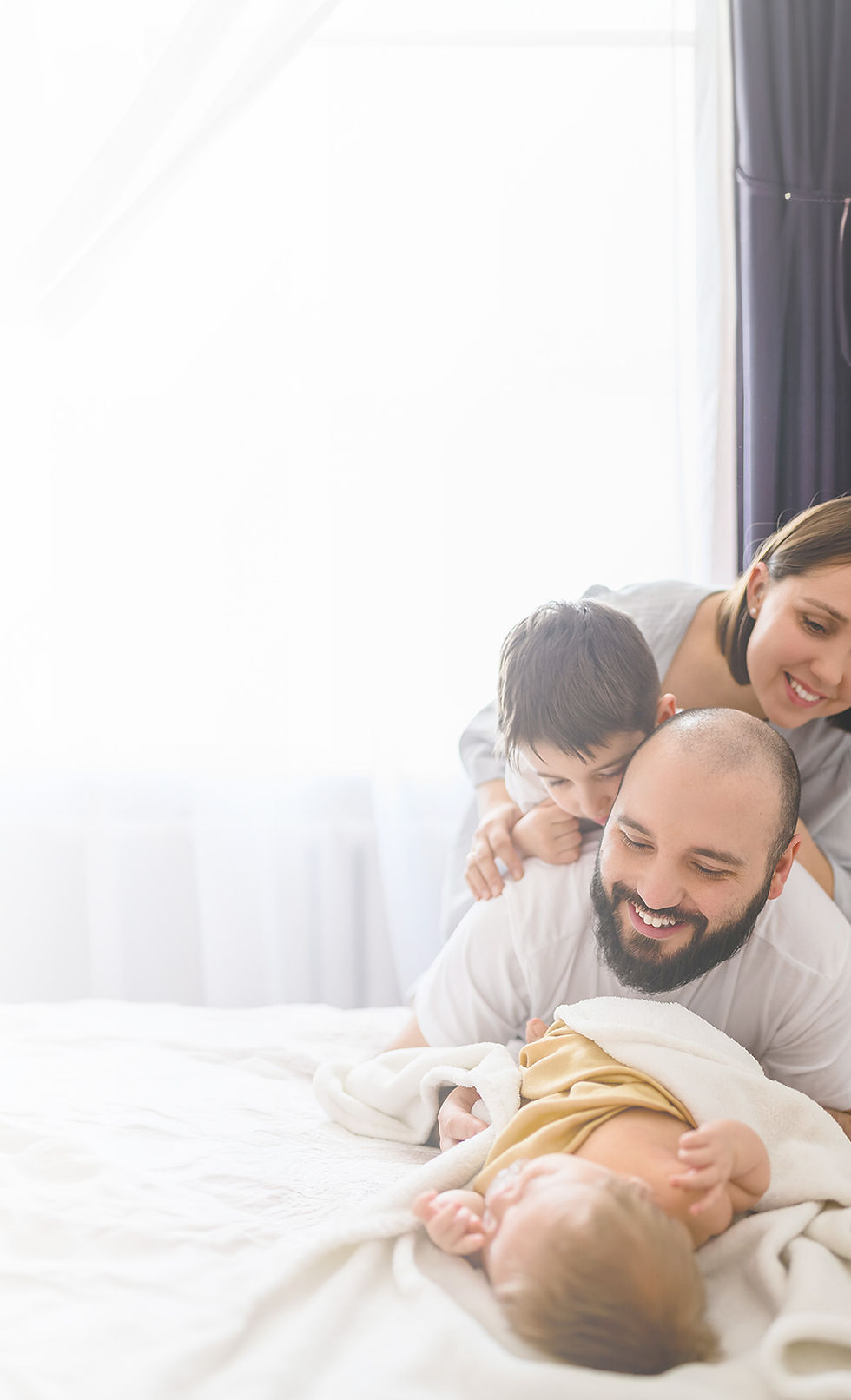 Happy family with three children on bed
