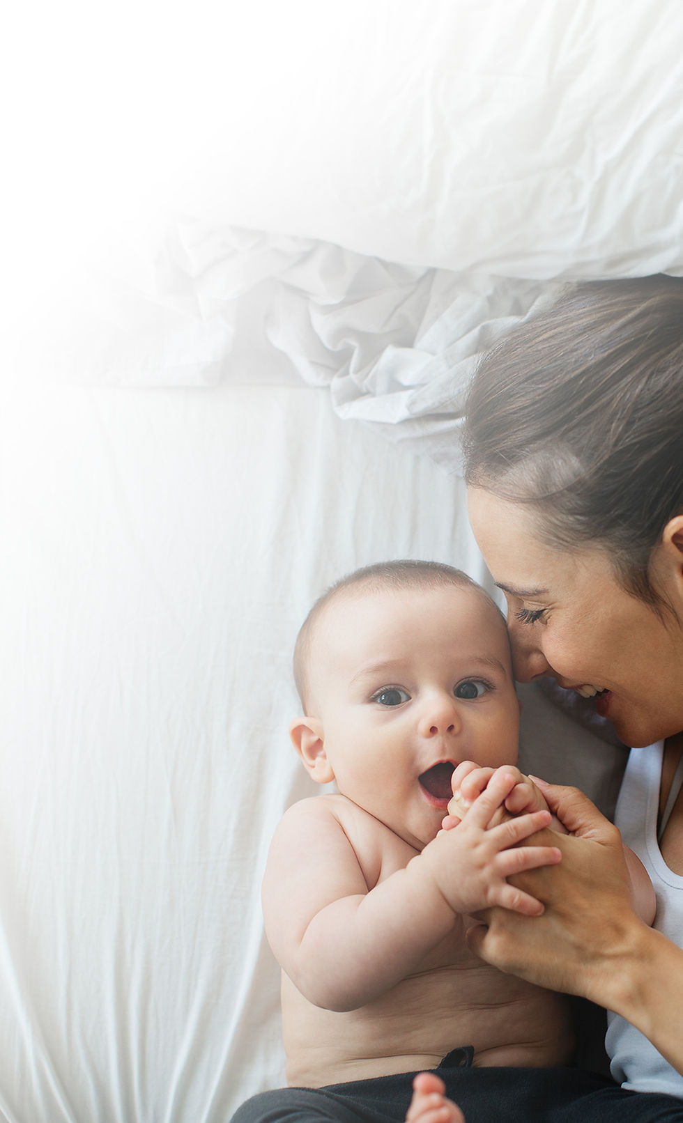 Happy mother and baby bonding on bed