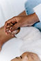 Close up on adult hand holding baby hand