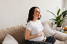 happy young pregnant woman on couch