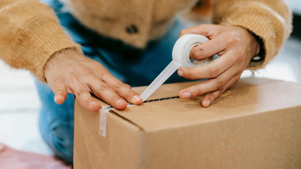 Woman writing on a packed cardboard box