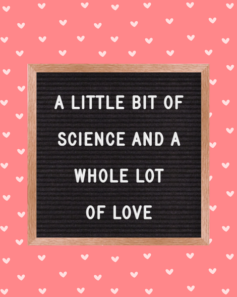 Blackboard with the text "a little bit of science and a whole lot of love" sitting on a pink background with white hearts.