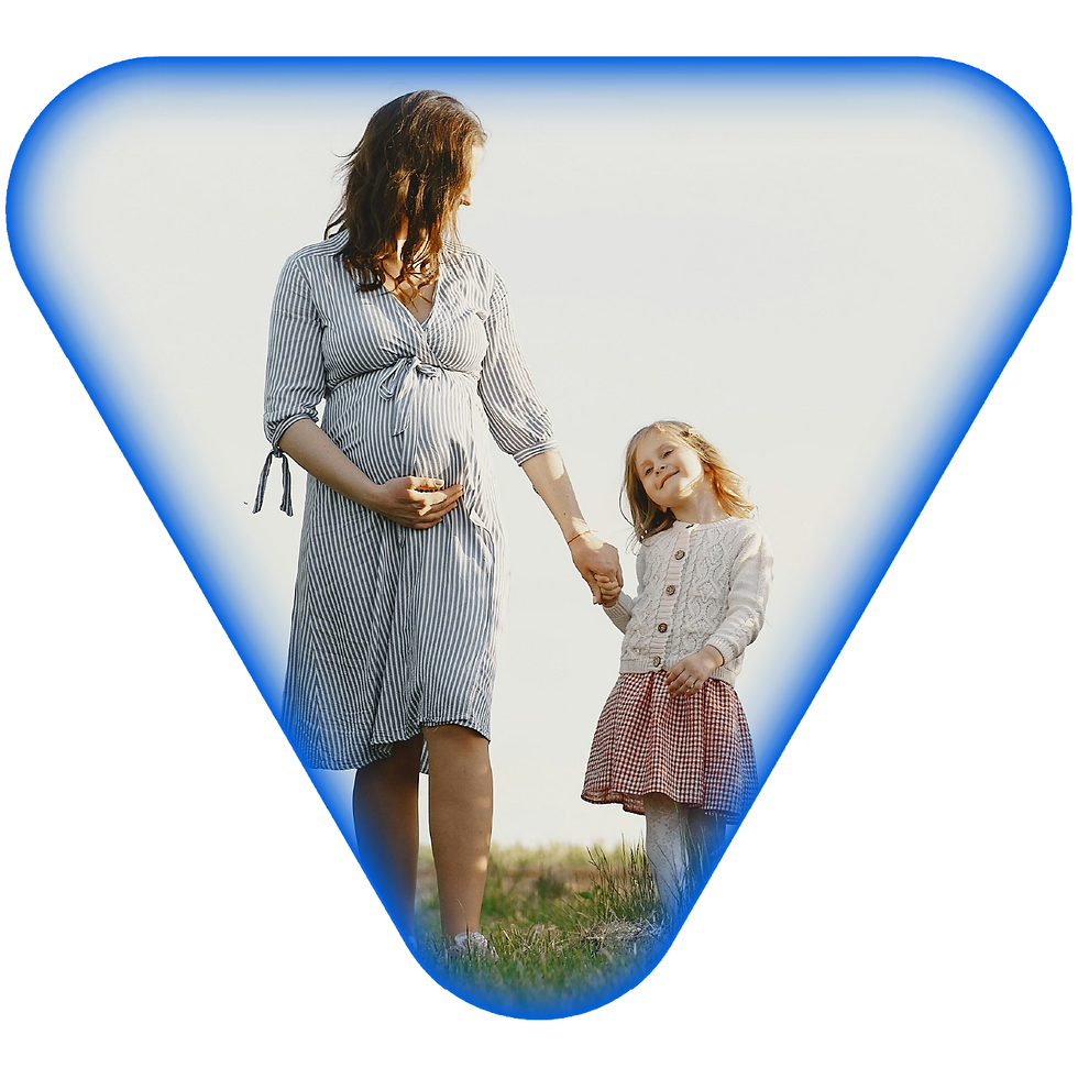 Woman holds the hand of a child while walking through a field